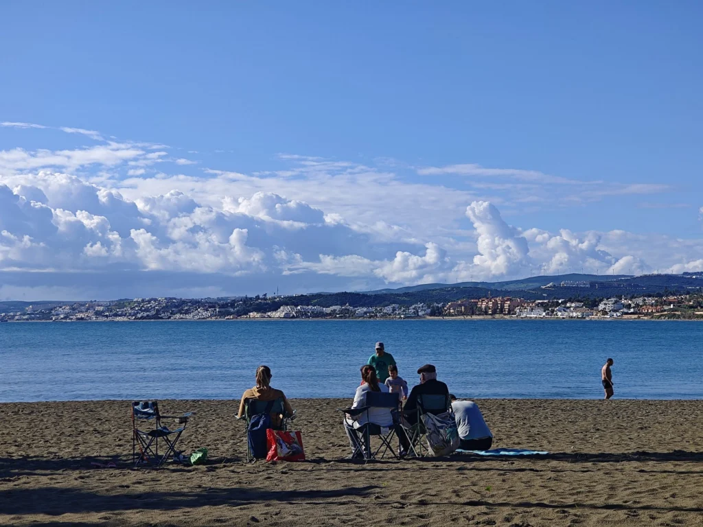 People on the beach in Estepona on New Year's Eve with a blue sea and sunshine