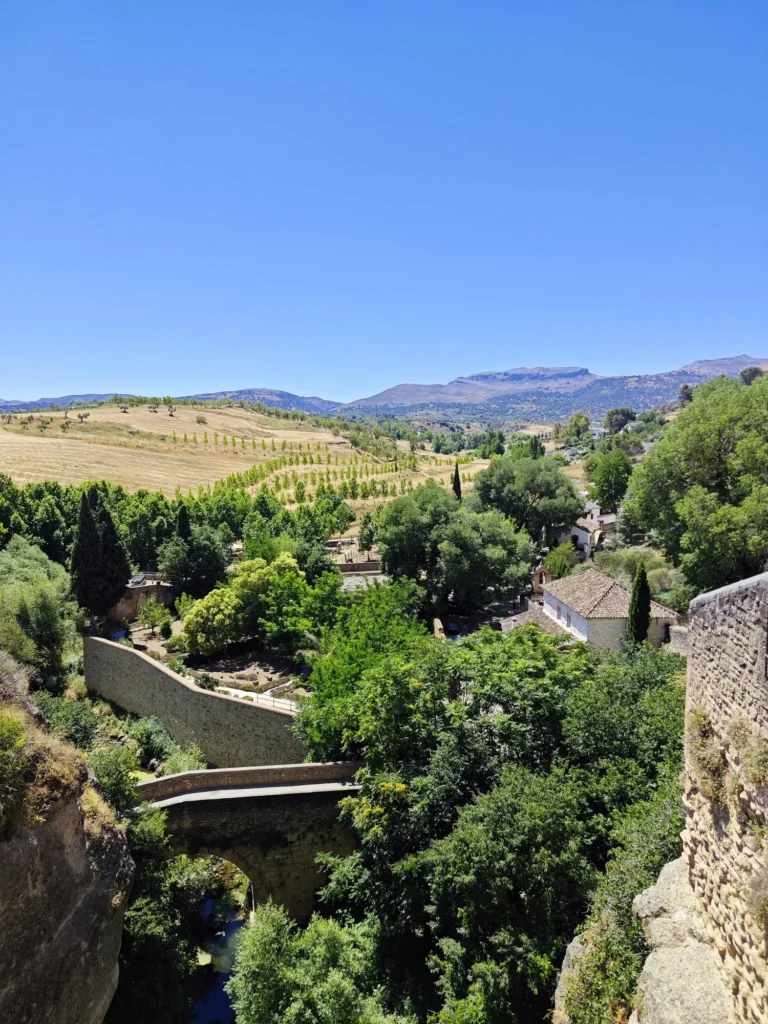 Old bridge in the green valley below Ronda